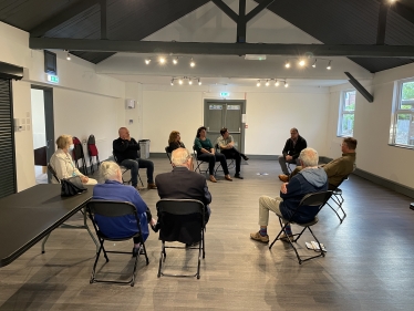 Mark speaking in a circle with residents