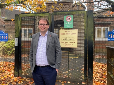 Mark standing by Glebe Junior School Sign