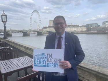 Mark on the terrace holding Destination Derby sign